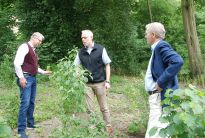 Die Spender Harald und Jens Emigholz mit Tim Großmann bei der Übergabe der Strauchpflanzungen